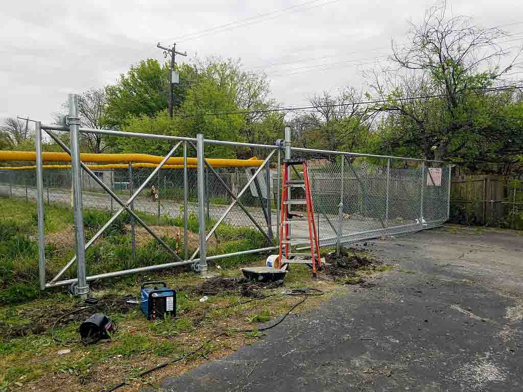 cantilever slide security gate mid-installation with ladder and tools on site